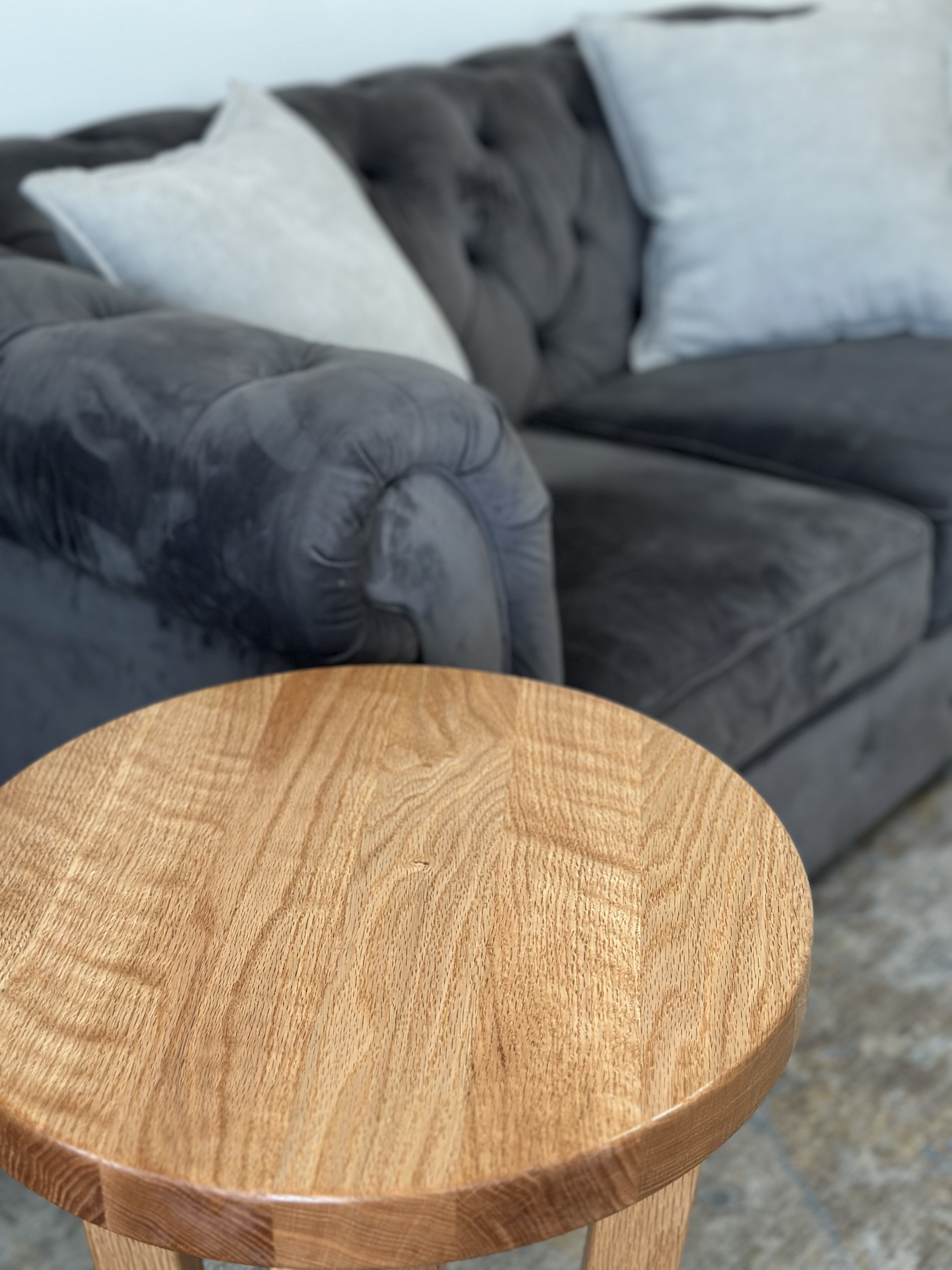Close-up of round end table top showing natural oak wood grain and smooth finish